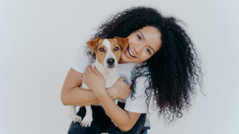 Woman cuddling pet in cosy home.